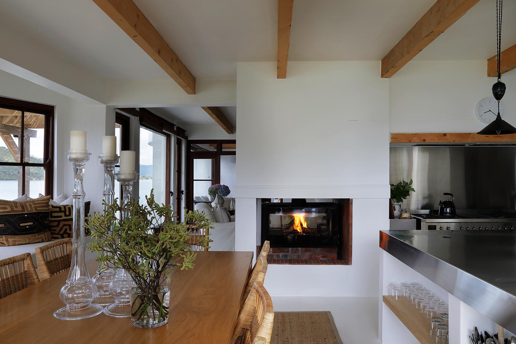 Perfect Hideaways: Dining table with tall glass candlesticks beside a double-sided hearth linking to the lounge, Knysna, Tides Reach