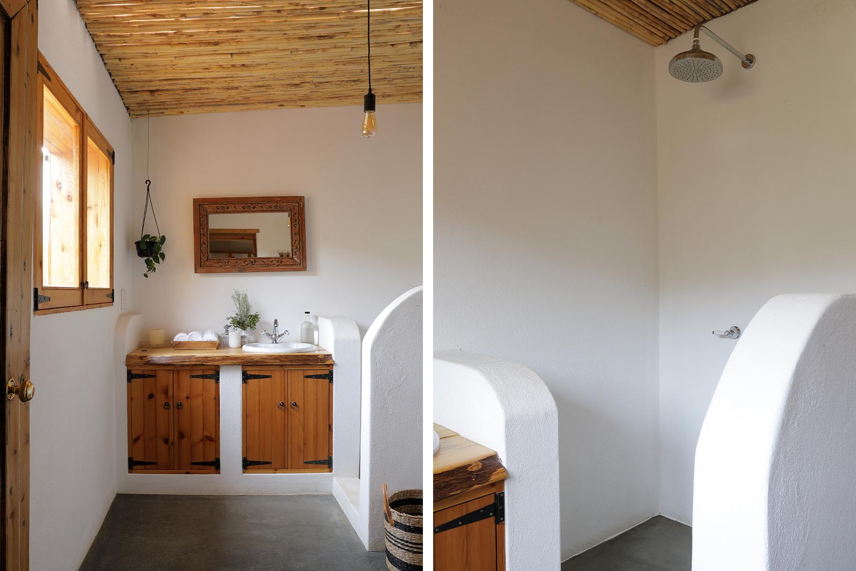 Perfect Hideaways – A simple bathroom space featuring a wooden vanity with rustic cabinets, a round basin, carved wooden mirror, and a hanging plant. Next to it, a curved white plaster wall leads into an open shower area with a minimalist rain showerhead. Sheperd's Cottage, Prince Albert
