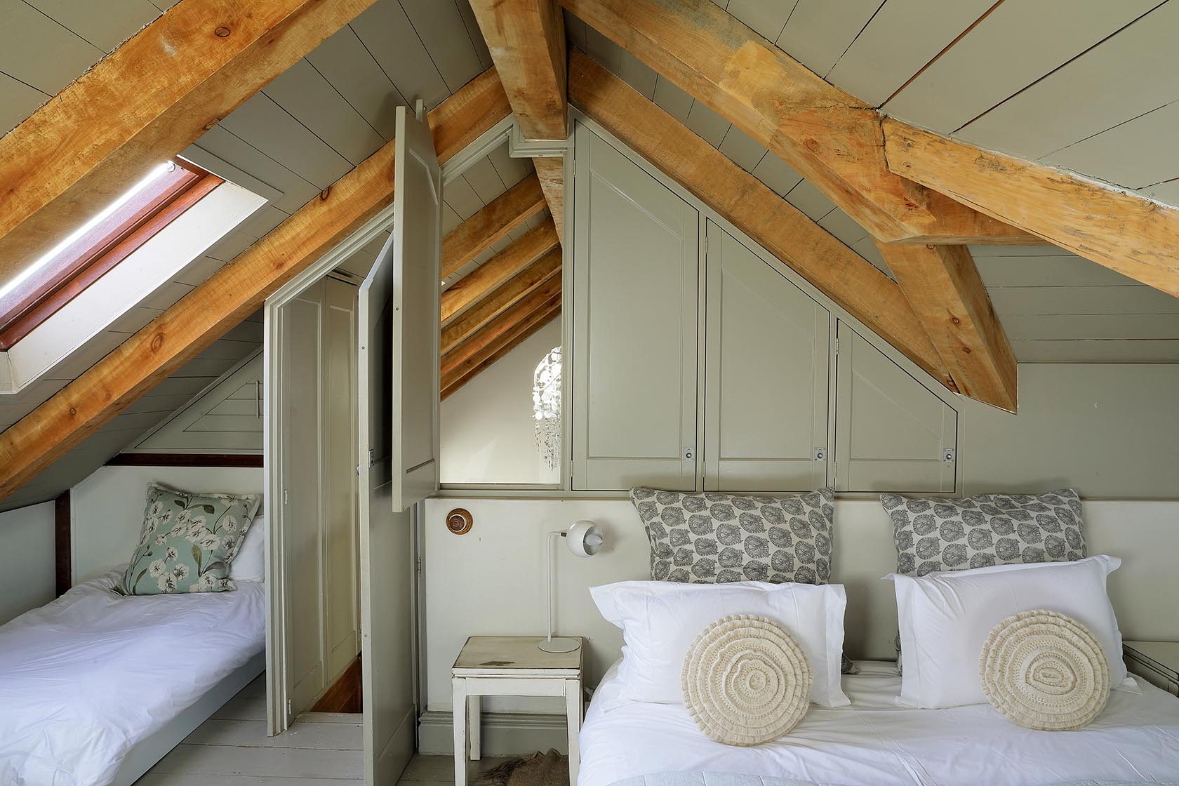 Perfect Hideaways–Loft bedroom with exposed beams, soft green cabinetry, and three single beds tucked under the eaves. Church Cottage, Churchhaven, South Africa