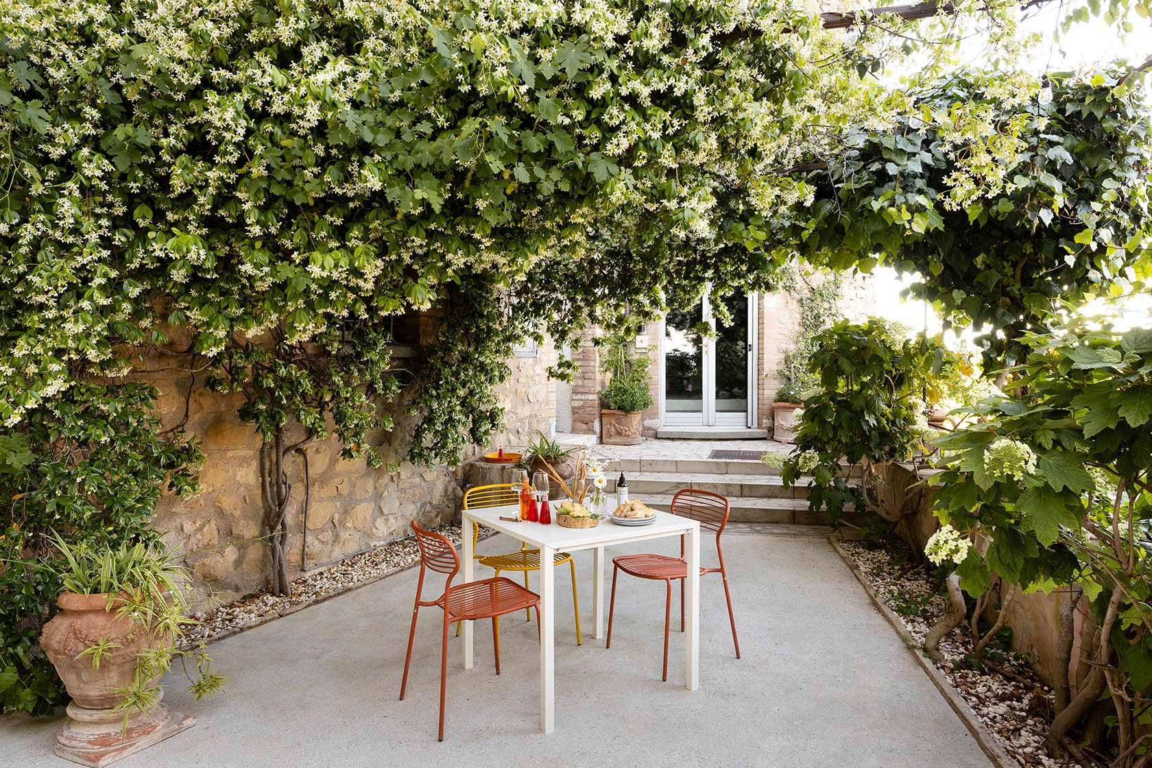 Perfect Hideaways shaded garden terrace with outdoor dining beneath flowering vines, Umbria Cottage, Collazzone