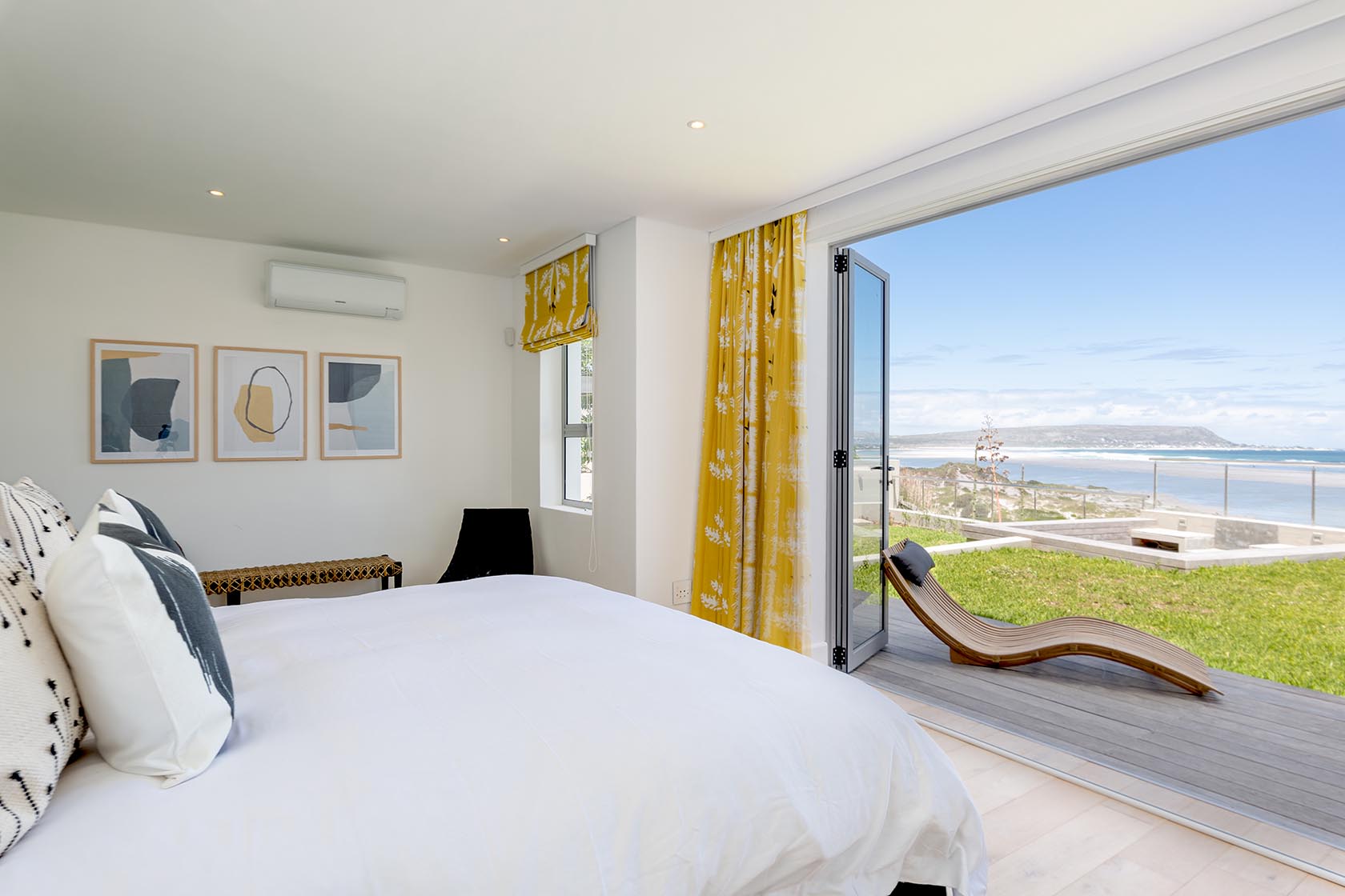 Perfect Hideaways - Elegant bedroom interior with open doors to a private deck, sun lounger and sweeping coastal views across Noordhoek Noordhoek Seashore_Noordhoek_Southern Peninsula_Cape Town_Western Cape_South Africa