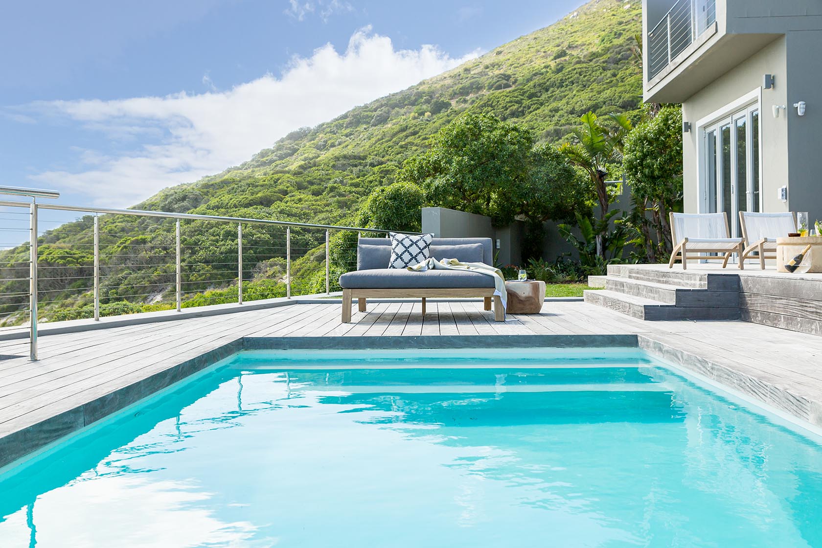 Perfect Hideaways - Tranquil pool deck set against lush hillside greenery, featuring outdoor seating and a turquoise swimming pool Noordhoek Seashore_Noordhoek_Southern Peninsula_Cape Town_Western Cape_South Africa