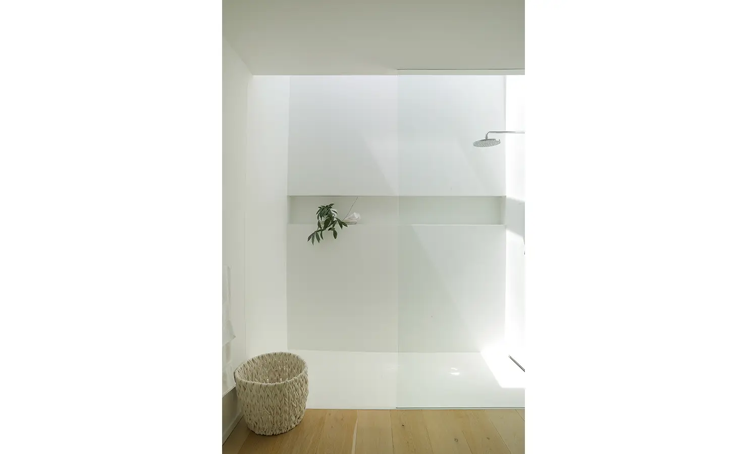 Perfect Hideaways A bright walk-in shower with seamless white finishes, soft natural light from above, and a woven basket set on pale timber floors Pure Living, Bishopscourt