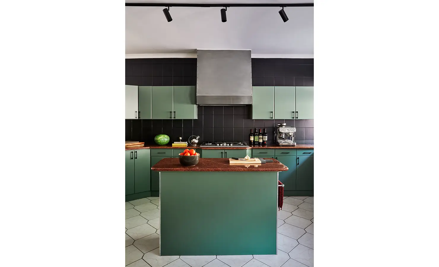 Perfect Hideaways a character-filled kitchen with green cabinetry, black tiled walls, a red stone island, and fresh produce on the counters illuminated by sleek black track lighting Camps Bay, The Liminal