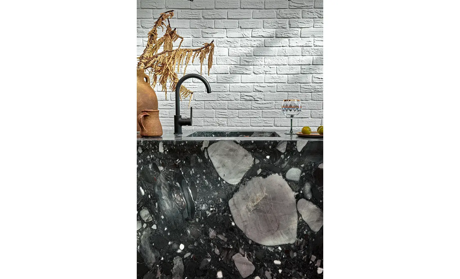 Perfect Hideaways a close-up of the striking black stone counter, highlighting its oversized mineral formations, matte black tap, rustic clay vessels, and textured white brick backdrop with soft reflected light Camps Bay, The Liminal