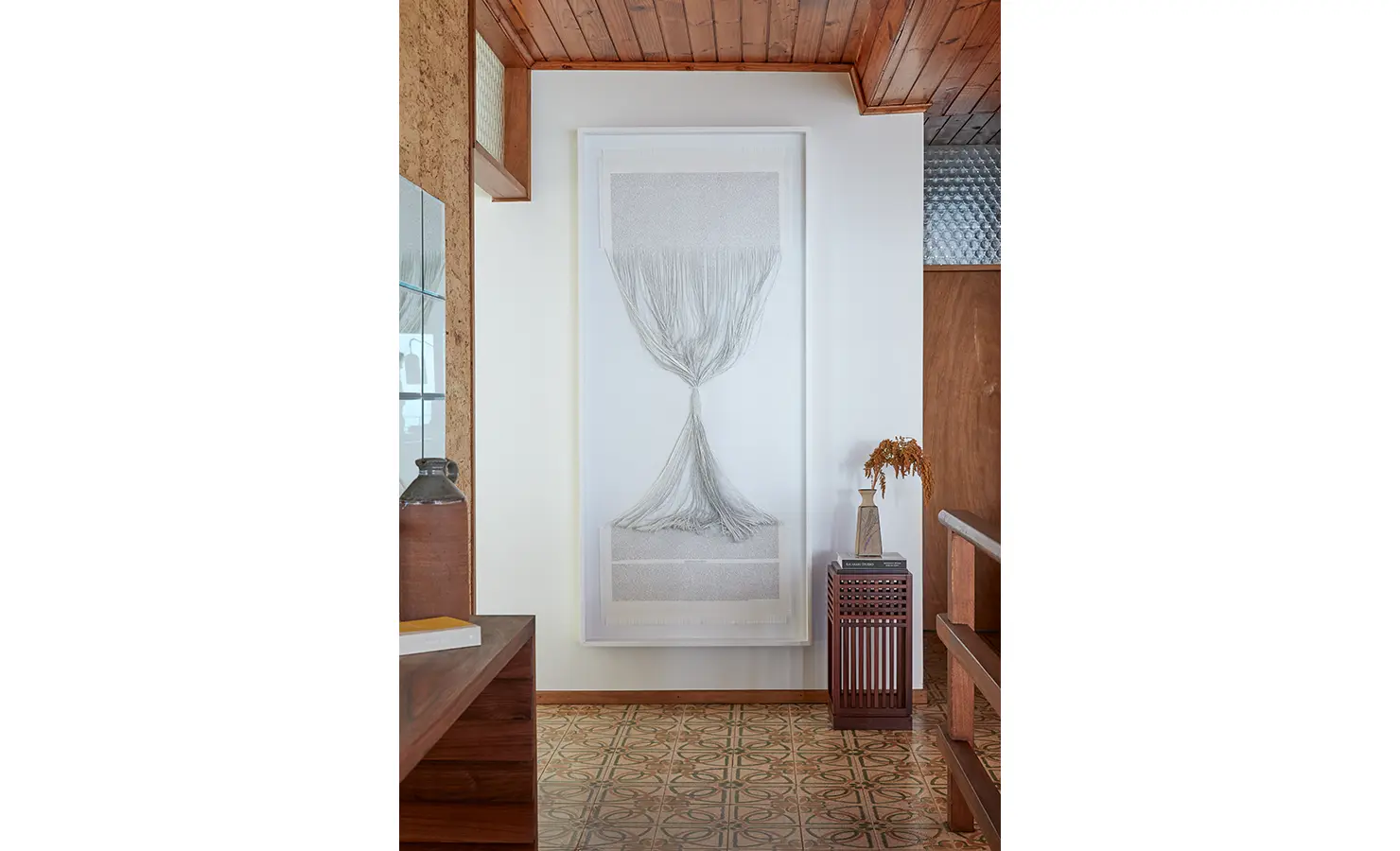 Perfect Hideaways a serene hallway space featuring an intricate monochrome textile artwork, patterned vintage floor tiles, warm timber accents, and a sculptural side table with dried botanical decor Camps Bay, The Liminal