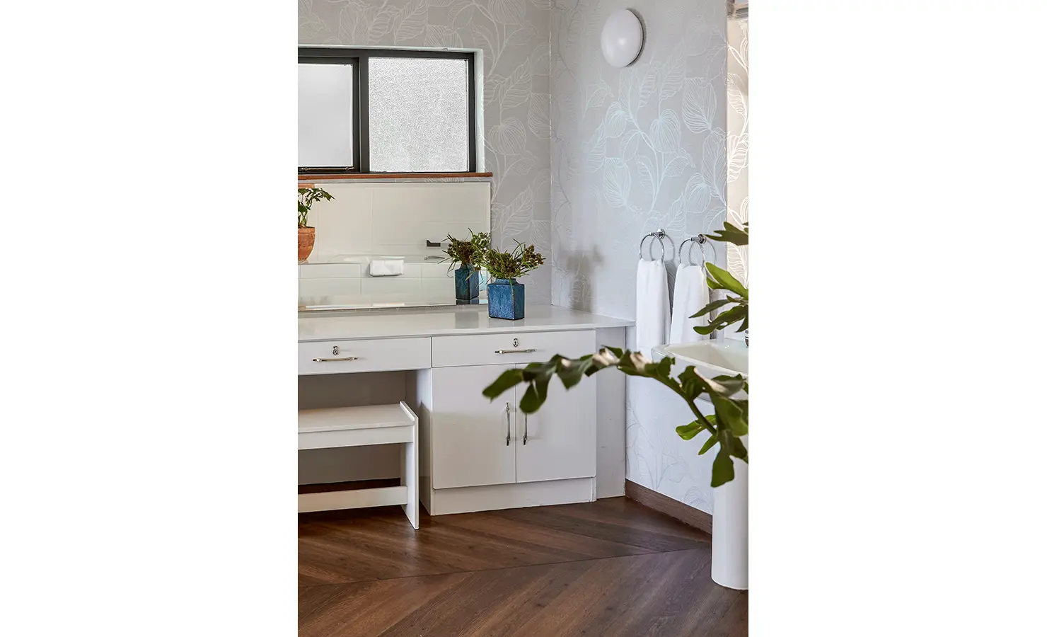 Perfect Hideaways a bright bathroom vanity area with white cabinetry, leafy wallpaper, natural greenery, and warm wood flooring creating a fresh and welcoming atmosphere Camps Bay, The Liminal