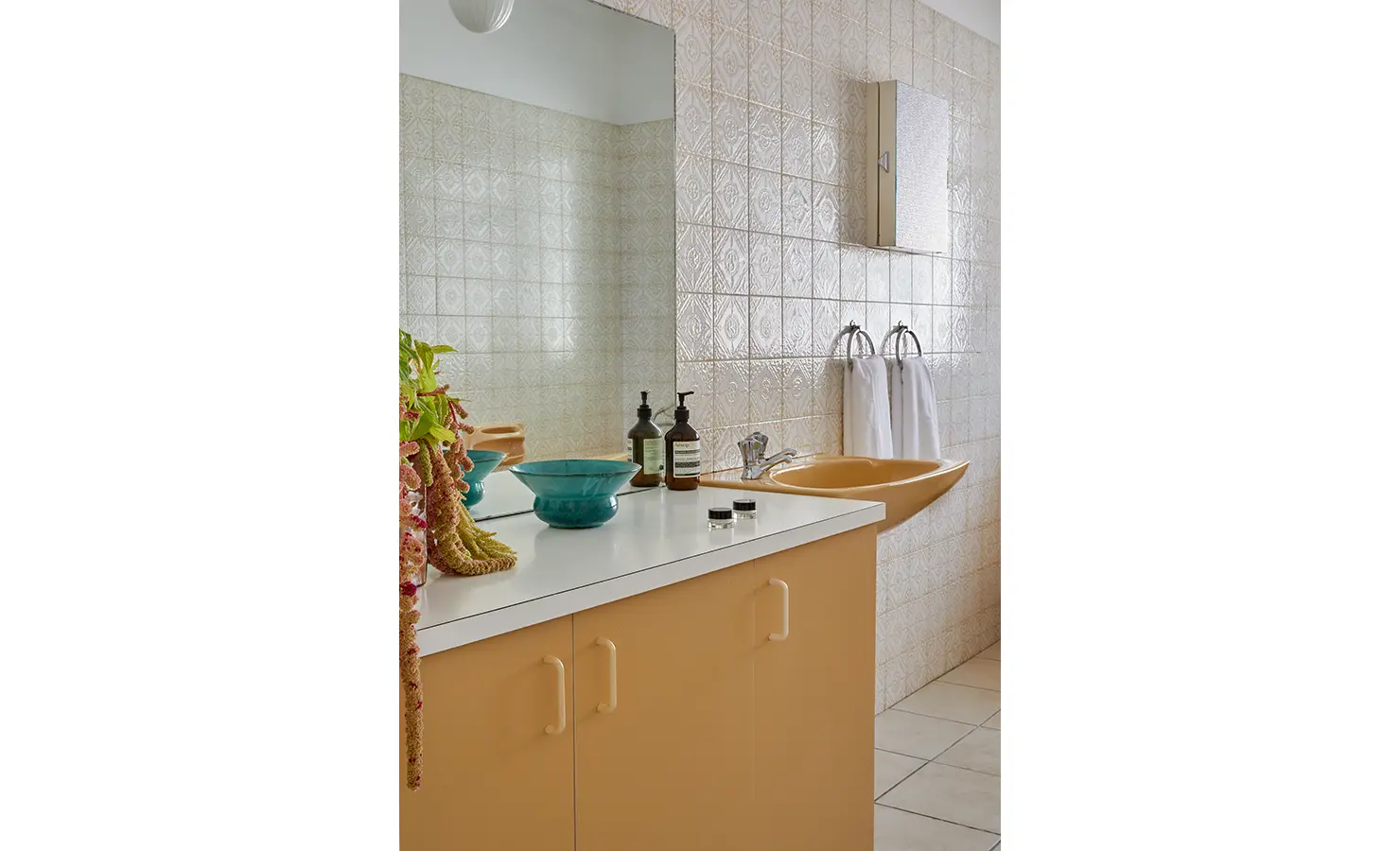 Perfect Hideaways a nostalgic bathroom with warm yellow cabinetry and matching basin, patterned cream wall tiles, and a counter styled with colourful ceramic bowls and botanical arrangements Camps Bay, The Liminal