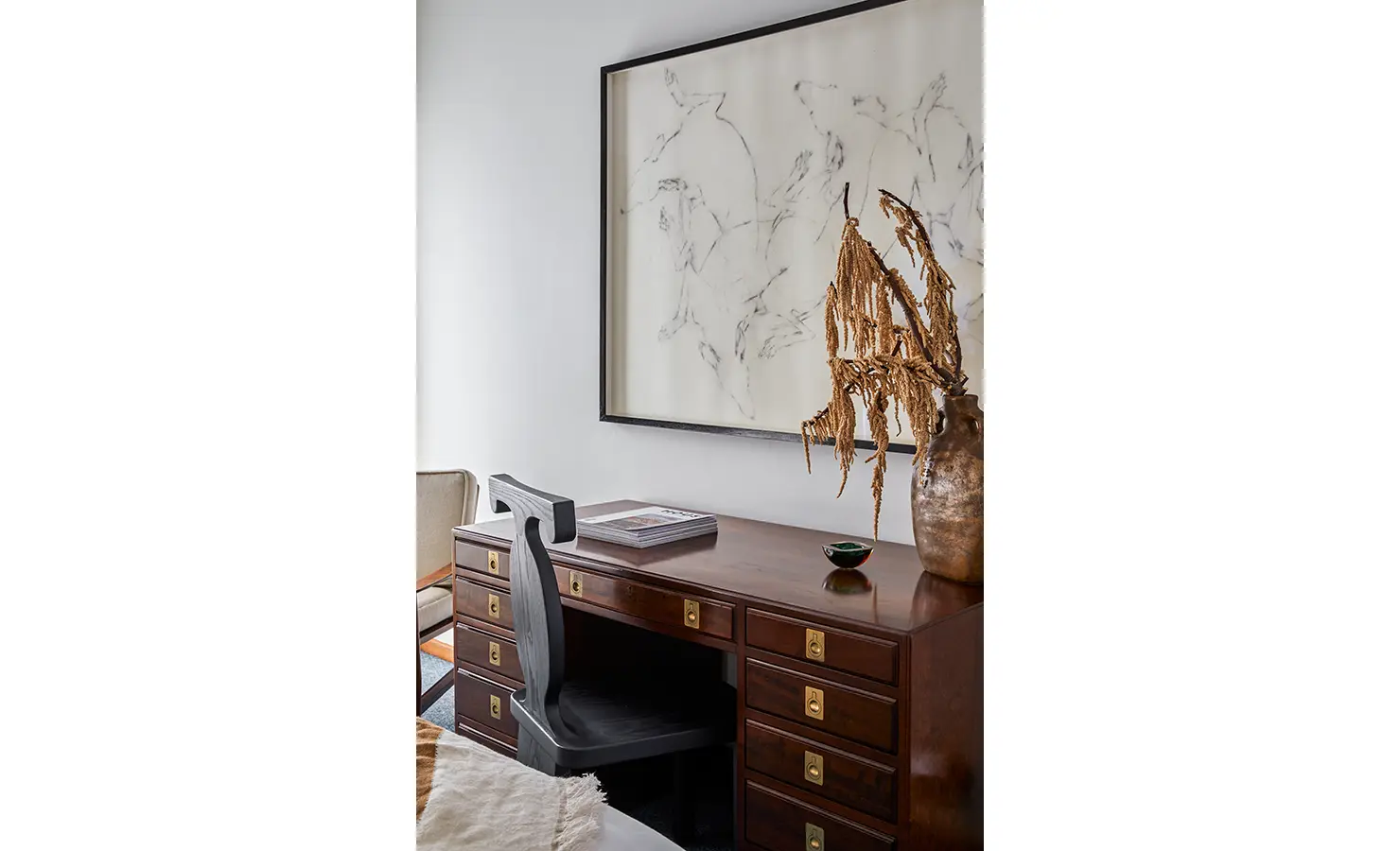 Perfect Hideaways a refined study corner with a dark wooden desk featuring brass hardware, a sculptural decorative vase, and a delicate large-scale sketch of running horses mounted above Camps Bay, The Liminal