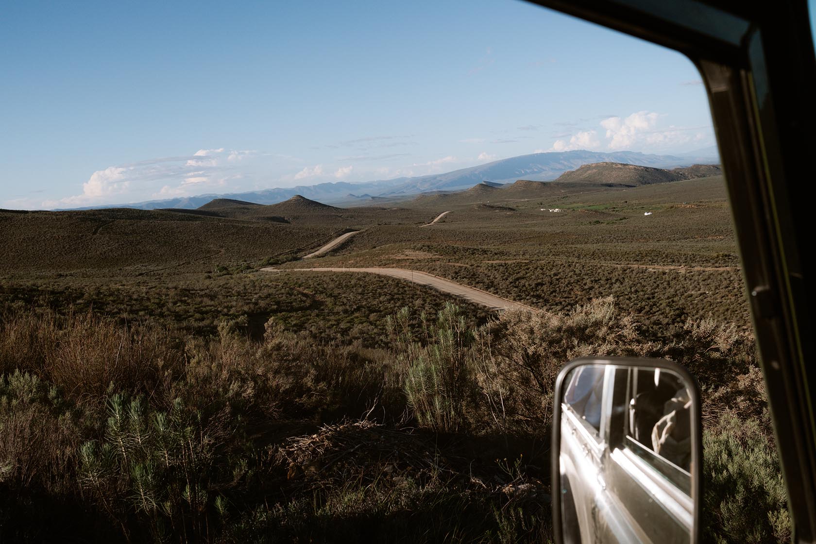 Perfect Hideaways scenic view of winding mountain roads and expansive Karoo landscapes seen from a vehicle, Jackals Rest, Montagu.