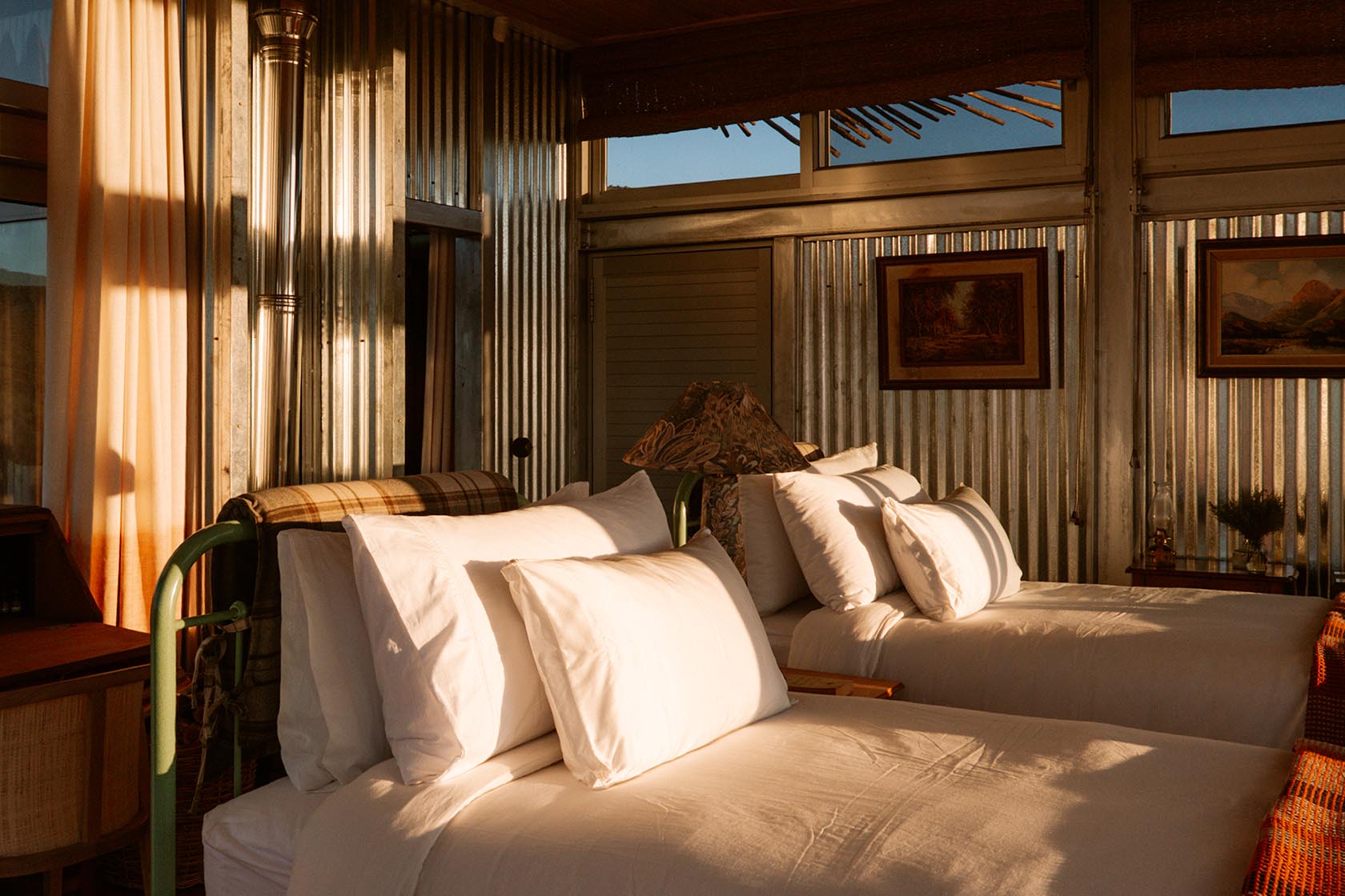 Perfect Hideaways twin bedroom with vintage-inspired furnishings, corrugated textures and golden afternoon light in the Karoo, Jackals Rest, Montagu.