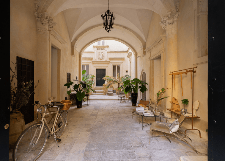 Palazzo Maresgallo’s entrance courtyard with cobblestones and relaxed seating, Lecce, Puglia